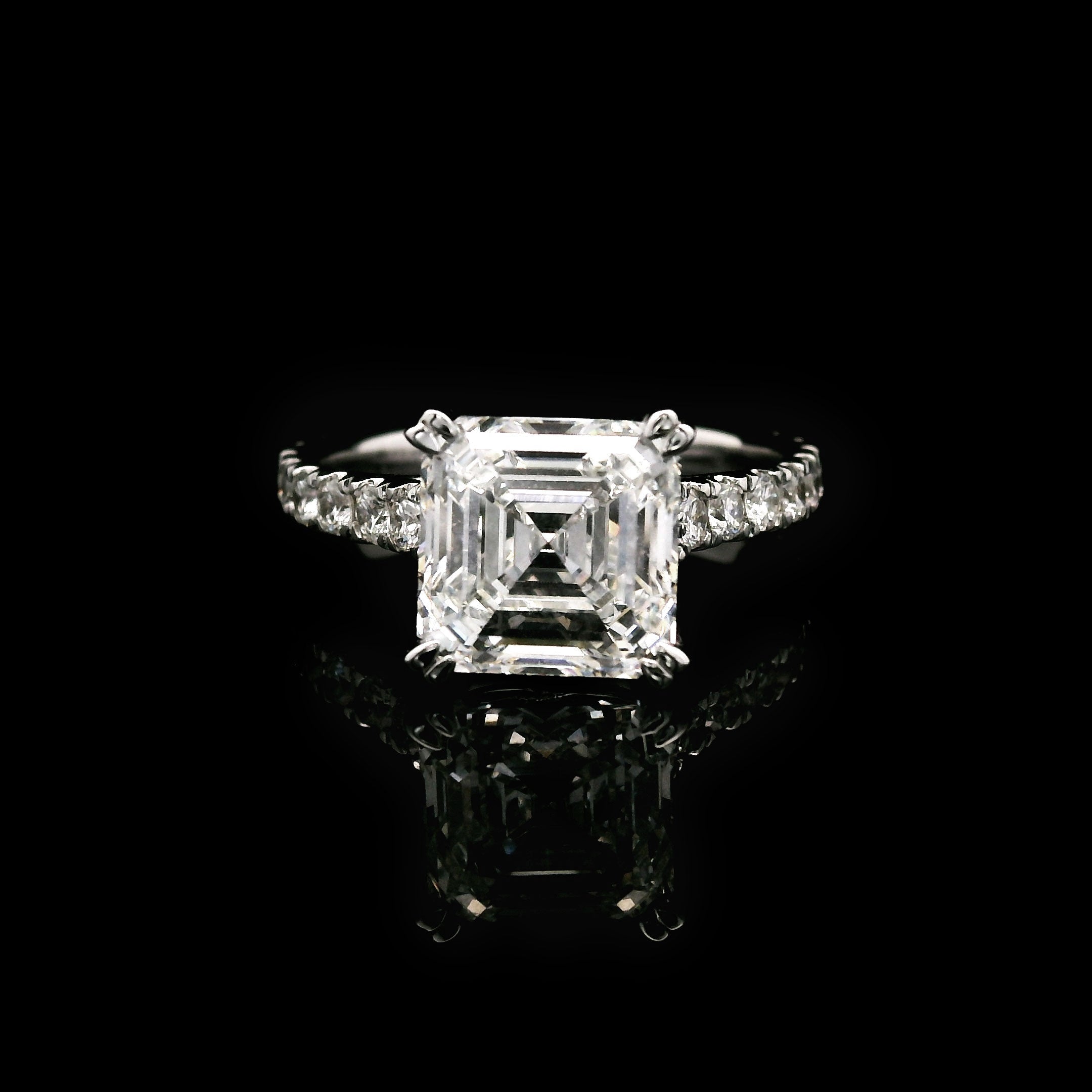 Diamond engagement ring with 3 carat Asscher cut center stone on a black background